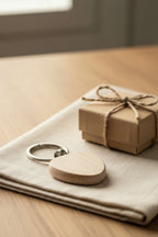 The beech heart keyring on a linen napkin next to a small gift box tied with twine