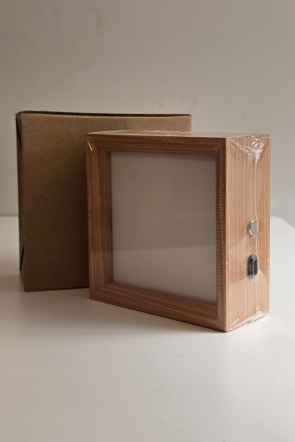 A new 4 inch night light in its protective wrap beside its kraft box