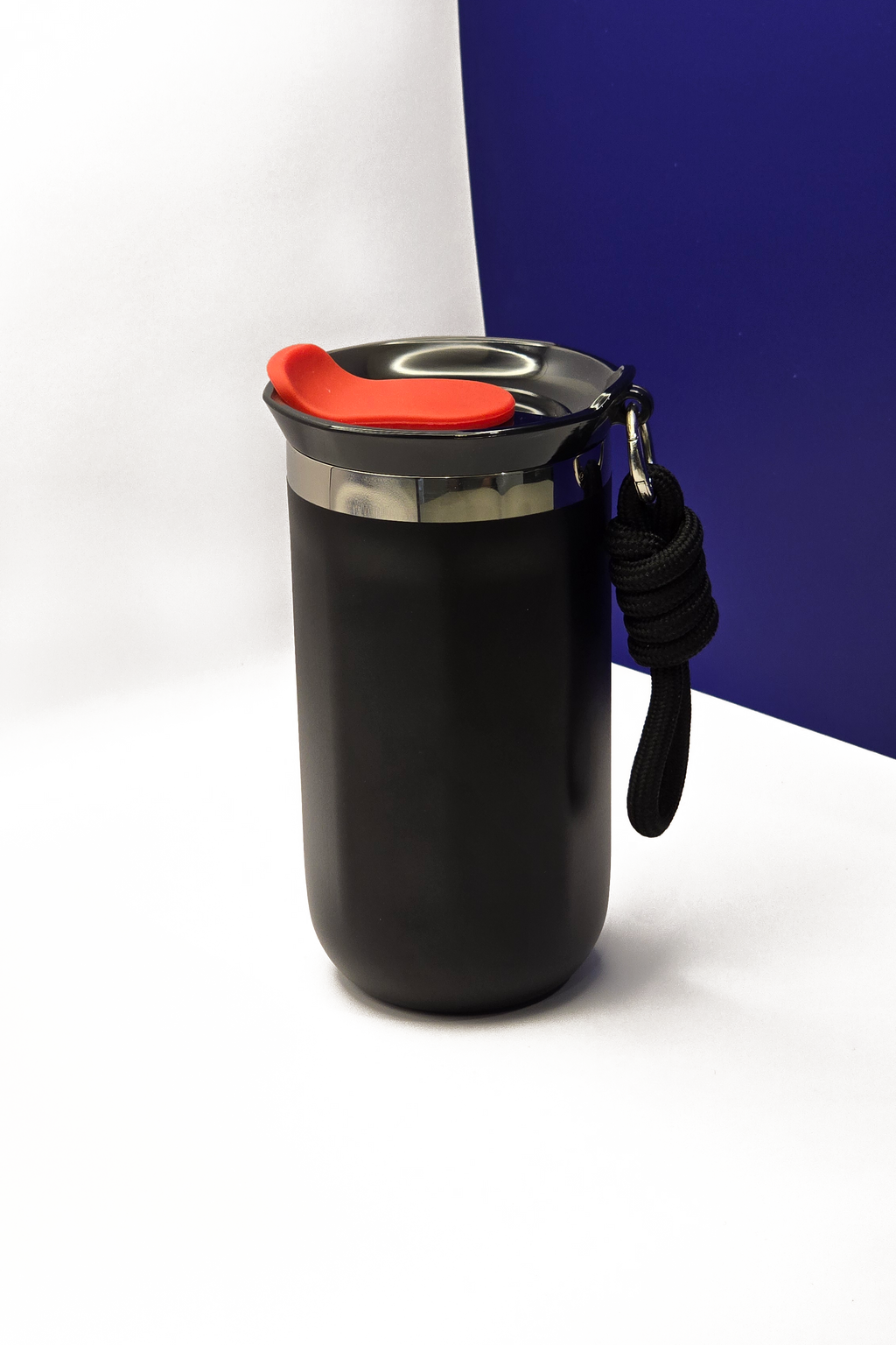 350ml matte black travel coffee cup, lid on, with the black carry rope clipped to its steel collar
