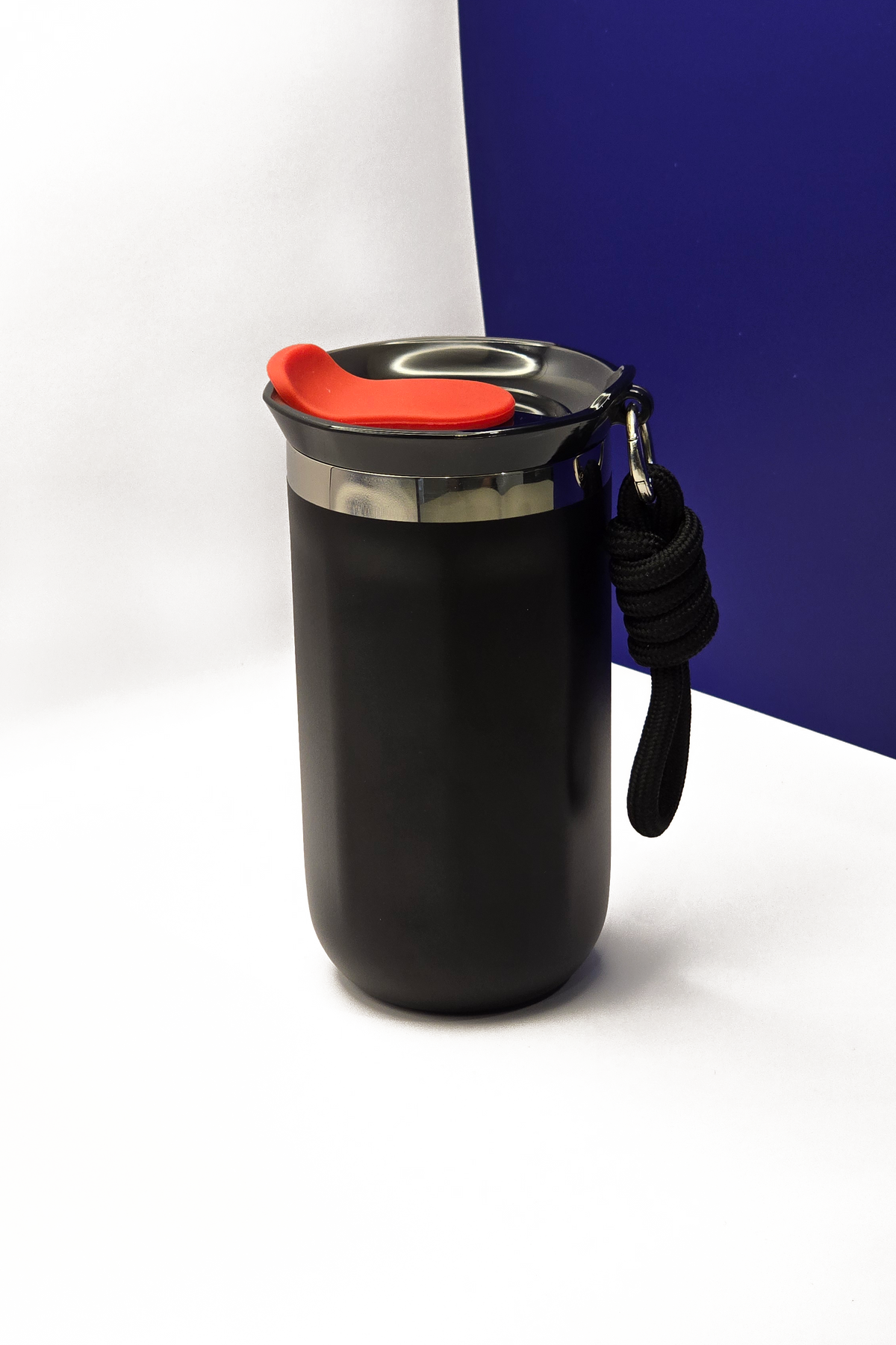 350ml matte black travel coffee cup, lid on, with the black carry rope clipped to its steel collar