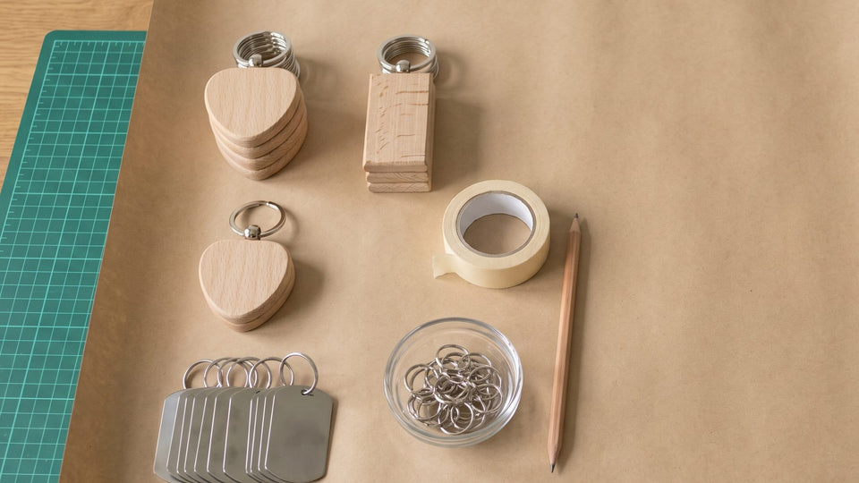 Plain beech and steel keyring blanks on kraft paper, ready to decorate